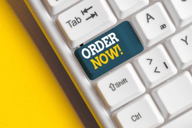 Şimdi Düzen'i gösteren kavramsal el yazısı. İş fotoğraf beyaz arka plan üzerinde not kağıdı ile Beyaz pc klavye satmak satın almak için bir taraf tarafından diğer doğrulanan istek vitrine.