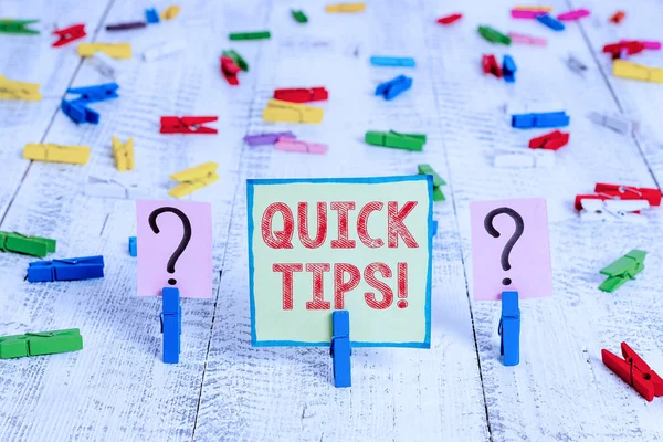 Handwriting text Quick Tips. Concept meaning small but particularly useful piece of practical advice Scribbled and crumbling sheet with paper clips placed on the wooden table.