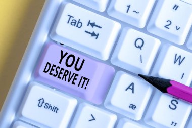 Conceptual hand writing showing You Deserve It. Business photo text should have it because of their qualities or actions White pc keyboard with note paper above the white background. clipart