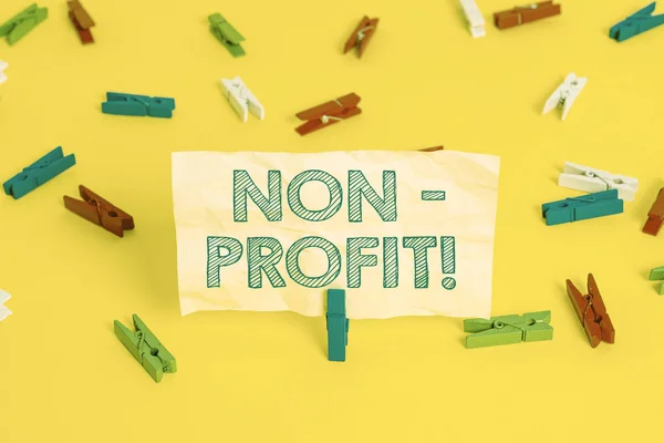 Nota di scrittura che mostra no profit. Business photo vetrina non fare o condotta principalmente per rendere l'organizzazione di profitto colorati cartine clothespin vuoto promemoria giallo pavimento fondo ufficio . — Foto Stock