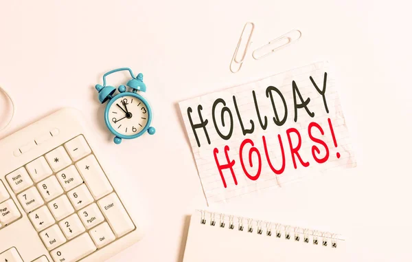 Writing note showing Holiday Hours. Business photo showcasing Overtime work on for employees under flexible work schedules Blank paper with copy space on the table with clock and pc keyboard.