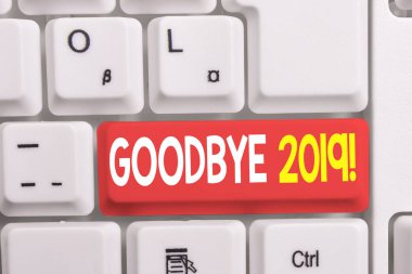 Goodbye 2019'u gösteren bir yazı. İş fotoğraf beyaz arka plan üzerinde not kağıdı ile geçen yıl beyaz pc klavye ayrılırken veya sonunda iyi dileklerini göstermek.