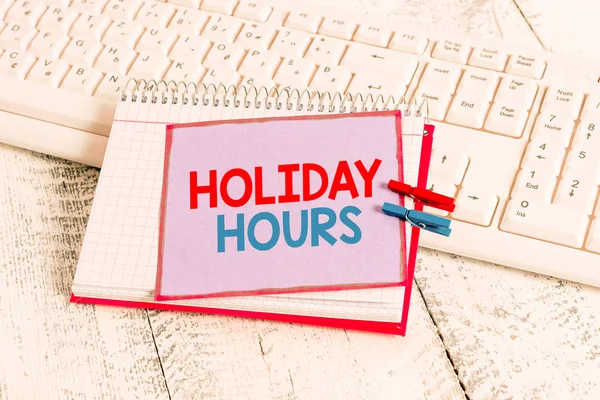 Word pisanie tekstu Holiday Hours. Koncepcja biznesowa dla pracownika otrzymuje dwa razy ich normalne wynagrodzenie za wszystkie godziny notatnik papier przypięty kartka klawiatura światło drewniane. — Zdjęcie stockowe