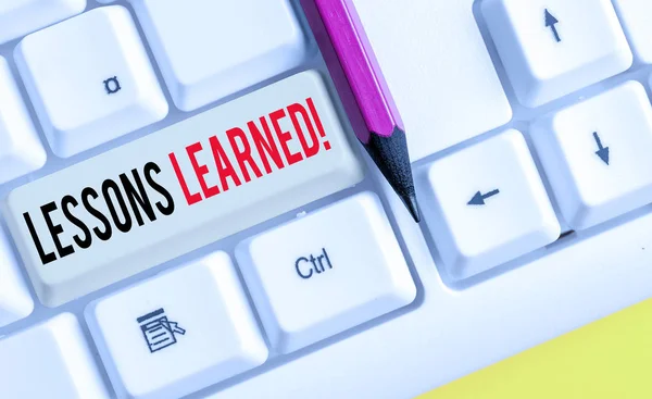 Escritura de palabras Lecciones aprendidas. Concepto de negocio para experiencias proyecto destilado que debe tomar activamente teclado blanco PC con papel de nota vacío sobre el espacio de copia de la tecla de fondo blanco . — Foto de Stock