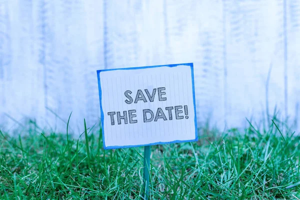 Handwriting text Save The Date. Concept meaning remember not schedule anything else on this day Plain empty paper attached to a stick and placed in the green grassy land. — Stock Photo, Image