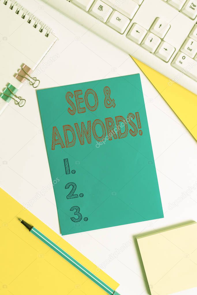 Conceptual hand writing showing Seo And Adwords. Business photo text they are main tools components of Search Engine Marketing Colored paper binder clip sheets white desk empty space.