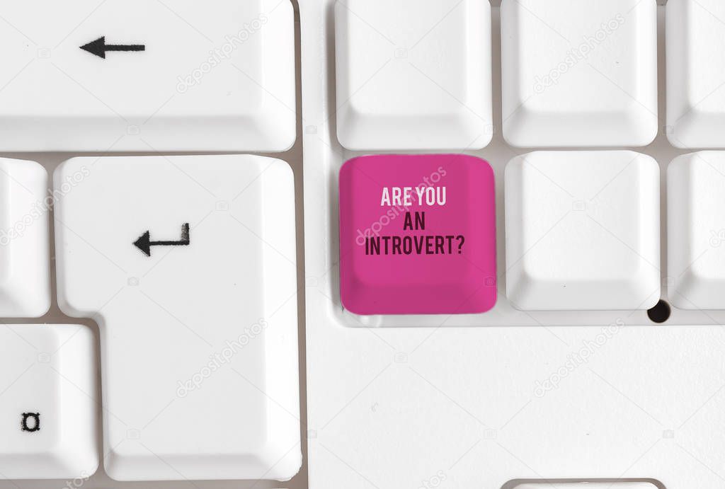 Conceptual hand writing showing Are You An Introvertquestion. Business photo text demonstrating who tends to turn inward mentally White pc keyboard with note paper above the white background.