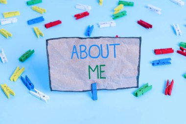 Handwriting text writing About Me. Concept meaning telling someone list of your good and bad traits and past events Colored clothespin papers empty reminder blue floor background office pin.