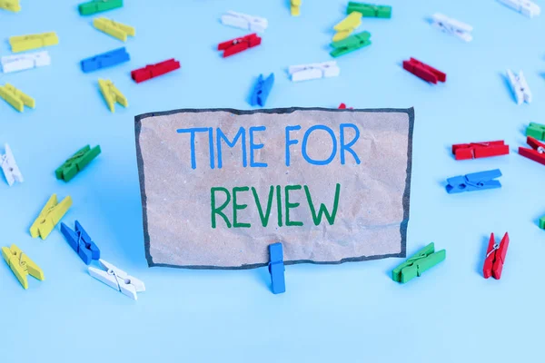 Handwriting text writing Time For Review. Concept meaning review of a system or situation in its formal examination Colored clothespin papers empty reminder blue floor background office pin.