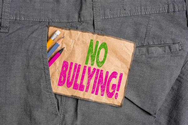 Handwriting text writing No Bullying. Concept meaning stop aggressive behavior among children power imbalance Writing equipment and brown note paper inside pocket of man work trousers.