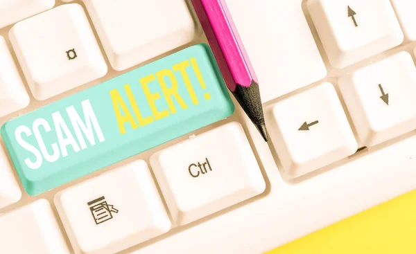 Handgeschreven tekst schrijven Scam Alert. Concept betekent frauduleus verkrijgen van geld van het slachtoffer door hem te overtuigen wit PC-toetsenbord met lege noot papier boven witte achtergrond sleutel kopiëren ruimte. — Stockfoto