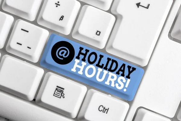 Text sign showing Holiday Hours. Conceptual photo Overtime work on for employees under flexible work schedules White pc keyboard with empty note paper above white background key copy space.