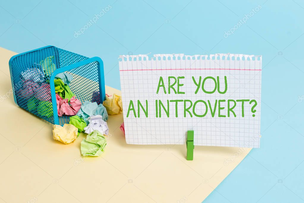 Text sign showing Are You An Introvertquestion. Conceptual photo demonstrating who tends to turn inward mentally Trash bin crumpled paper clothespin empty reminder office supplies tipped.