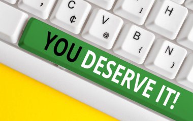 Word yazma metni You Deserve It. İş kavramı için nitelikleri veya eylemleri beyaz arka plan tuş kopyalama alanı üzerinde boş not kağıdı ile Beyaz pc klavye nedeniyle olmalıdır.