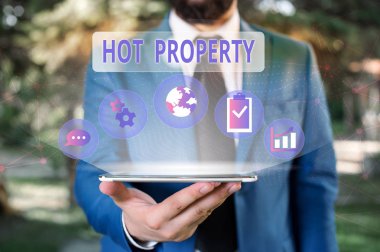 El yazısı metin Hot Property. Kavram anlamı Bir şey sonra aranan ya da Ağır Deanalysisded Erkek insan giyim resmi iş elbisesi akıllı cihaz kullanılarak sunum sunan.
