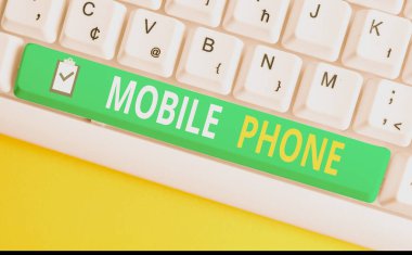 Cep Telefonu yazma el yazısı metin. Kavram anlamı Aramaları ve mesajları almak için kullanılan bir el cihazı Beyaz pc klavye beyaz arka plan tuşu kopyalama alanı üzerinde boş not kağıdı ile.