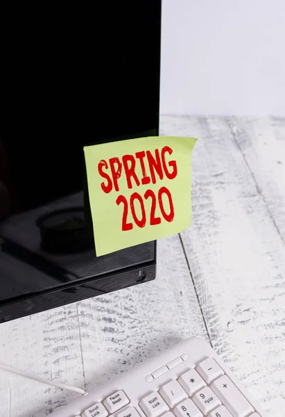 Word writing text Spring 2020. Business concept for time of year where flowers rise following winter season Notation paper taped to black computer monitor screen near white keyboard.