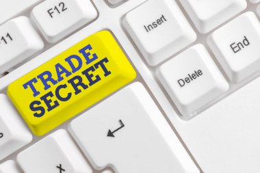 El yazısı metin Trade Secret. Kavram anlamı Bir ürün hakkında gizli bilgi Fikri mülkiyet Beyaz pc klavye beyaz arka plan anahtar kopyalama alanı üzerinde boş not kağıdı ile.