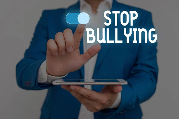 Word writing text Stop Bullying. Business concept for Fight and Eliminate this Aggressive Unacceptable Behavior Male human wear formal work suit presenting presentation using smart device.