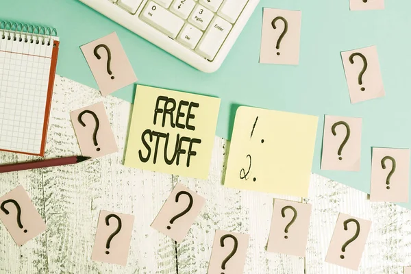 Conceptual hand writing showing Free Stuff. Business photo text Any thing that you can have in a store that is not being paid Writing tools and scribbled paper on top of the wooden table.