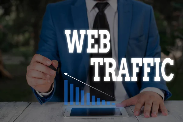 Handwriting text writing Web Traffic. Concept meaning Amount of data sent and received by visitors to a website Male human wear formal work suit presenting presentation using smart device.