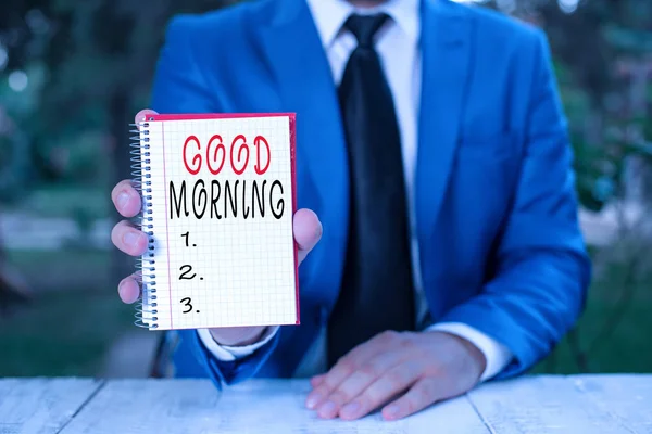 Text sign showing Good Morning. Conceptual photo A conventional expression at meeting or parting in the morning Man holds empty paper with copy space in front of him.