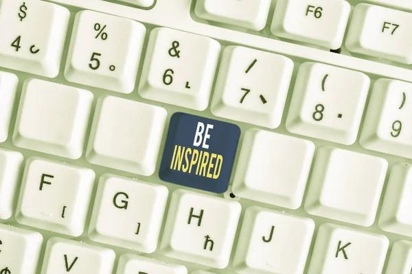 Scrittura a mano concettuale che mostra Be Inspired. Business foto testo qualità straordinaria come derivanti da qualche impulso creativo tastiera pc bianco con carta nota sopra lo sfondo bianco . — Foto Stock