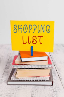 Alışveriş Listesini gösteren kavramsal el yazısı. İş fotoğraf vitrin Disiplin yaklaşımı alışveriş için Temel Öğeler kazık yığılmış kitap not defteri pin renk hatırlatma beyaz ahşap satın almak için.