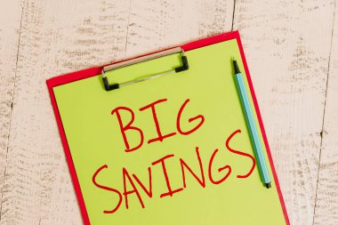 El yazısı metin Big Savings. Kavram anlamı gelir harcanmamış veya ertelenmiş tüketim kenara para koyarak Renkli pano boş kağıt levha kalem eski ahşap vintage arka plan.