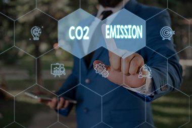 Kelime yazma metin Co2 Emisyon. Zaman içinde atmosfere sera gazlarının serbest bırakılması için İş konsepti Erkek giyim resmi iş elbisesi akıllı cihaz kullanarak sunum sunan.