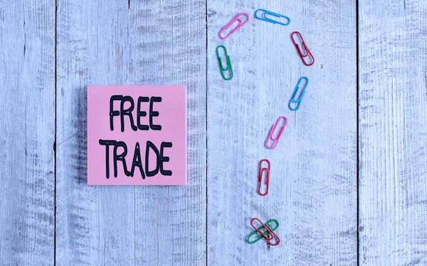 Writing note showing Free Trade. Business photo showcasing The ability to buy and sell on your own terms and means Pastel colour note paper placed next to stationary above wooden table.