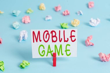 Mobil Oyunu gösteren kavramsal el yazısı. Onlar akıllı cihaz Renkli clothespin dikdörtgen şekilli kağıt mavi arka plan üzerinde çalışmak için yapılan eğlenceli programlar vitrin.