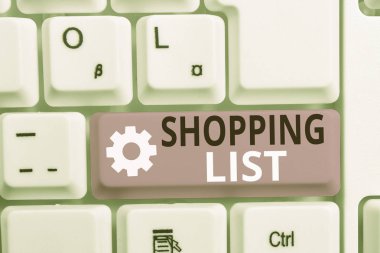 Alışveriş Listesini gösteren not yazma. İş fotoğraf vitrin Disiplin yaklaşımı alışveriş için Temel Öğeler beyaz arka plan üzerinde not kağıdı ile Beyaz pc klavye satın almak.