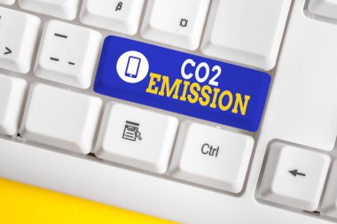 El yazısı metin Co2 Emisyon. Kavram anlamı zaman içinde atmosfere sera gazlarının serbest bırakılması Beyaz pc klavye beyaz arka plan anahtar kopyalama alanı üzerinde boş not kağıdı ile.