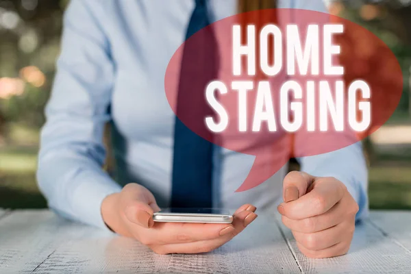 Schrijven van de opmerking Home Staging. Zakelijke fotopresentatie van de handeling van de voorbereiding van een prive-woning te koop in de markt vrouwelijke zakelijke persoon zittend per tafel en het houden van mobiele telefoon. — Stockfoto