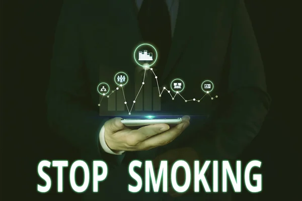 禁煙を示すテキスト記号。概念写真 タバコ中毒の使用を中止または中止 男性はスマートデバイスを使用してプレゼンテーションを提示する正式な作業スーツを着用. — ストック写真