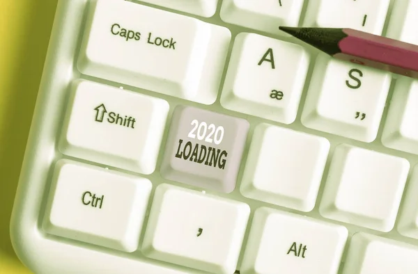 Writing note showing 2020 Loading. Business photo showcasing Advertising the upcoming year Forecasting the future event White pc keyboard with note paper above the white background.