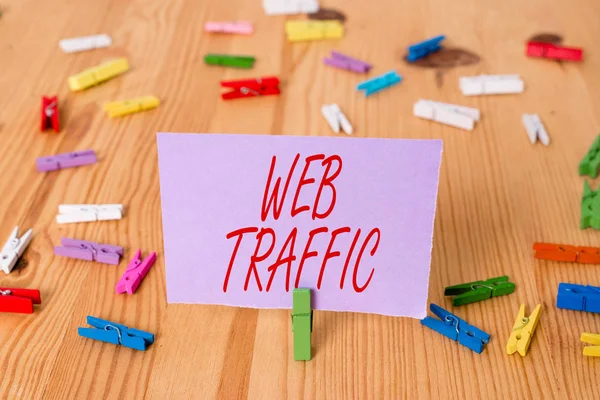 Handwriting text Web Traffic. Concept meaning Amount of data sent and received by visitors to a website Colored clothespin papers empty reminder wooden floor background office.