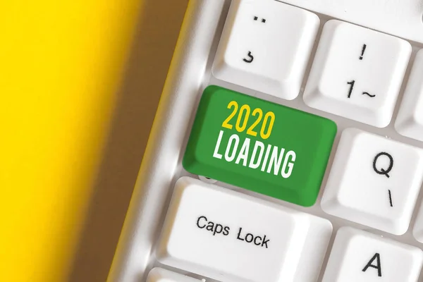 Handwriting text writing 2020 Loading. Concept meaning Advertising the upcoming year Forecasting the future event White pc keyboard with empty note paper above white background key copy space. — Stock Photo, Image