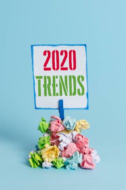 Kelime yazma metni 2020 Trendler. Cari yıl içinde kısa bir süre için ünlü şeyler için iş konsepti Hatırlatma kazık renkli buruşuk kağıt clothespin hatırlatma mavi arka plan.