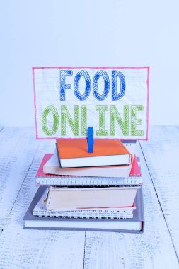 Kelime yazma metin Food Online. Telefon uygulaması veya web sitesi kazık yığılmış kitaplar defter pin clothespin renkli hatırlatma beyaz ahşap kullanarak yemek için bir şey soran için Iş kavramı.