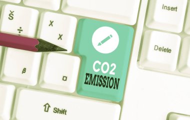 Kelime yazma metin Co2 Emisyon. Zaman içinde atmosfere sera gazlarının serbest bırakılması için Iş konsepti Beyaz pc klavye beyaz arka plan anahtar kopyalama alanı üzerinde boş not kağıdı ile.