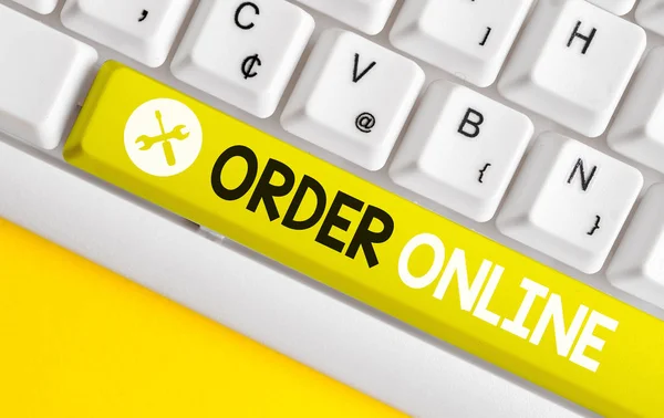 Conceptual hand writing showing Order Online. Business photo text Buying goods and services from the sellers over the internet White pc keyboard with note paper above the white background.