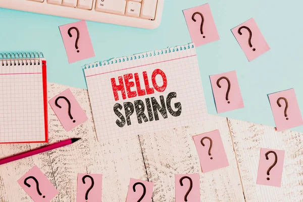 Znak tekstowy przedstawiający Hello Spring. Zdjęcie koncepcyjne powitanie sezonu po zimie kwitnących kwiatów narzędzia do pisania, rzeczy komputerowe i arkusz książki matematyki na szczycie drewnianego stołu. — Zdjęcie stockowe