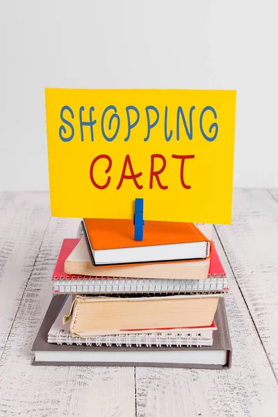 Conceptual hand writing showing Shopping Cart. Business photo showcasing Case Trolley Carrying Groceries and Merchandise pile stacked books notebook pin color reminder white wooden.