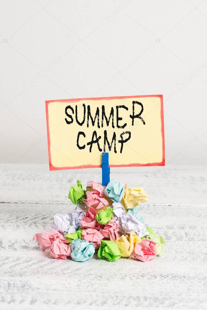 Writing note showing Summer Camp. Business photo showcasing Supervised program for kids and teenagers during summertime. Reminder pile colored crumpled paper clothespin wooden space.