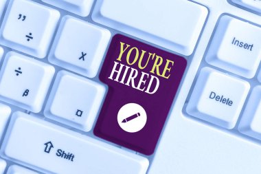 El yazısı metin yazma You Re Hired. Kavramı anlamı Yeni İş İstihdam Newbie Kayıtlı Kabul İşe Beyaz pc klavye beyaz arka plan anahtar kopyalama alanı üzerinde boş not kağıdı ile.