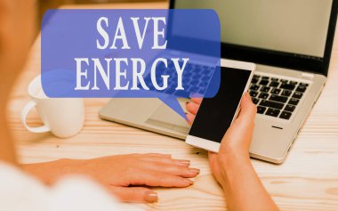 Kelime yazma metni Enerji tasarrufu. Benzer bir sonuç kadın dizüstü bilgisayar akıllı telefon kupa ofis malzemeleri teknolojik cihazlar elde etmek için kullanılan güç miktarını azaltmak için iş konsepti.