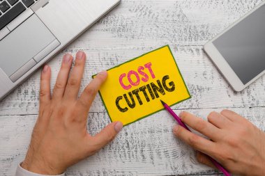 Cost Cutting 'i gösteren kavramsal el yazısı. İş fotoğraflarının gösterilmesi harcamaların azaltılması ve kârın artırılması için uygulanan tedbirler.
