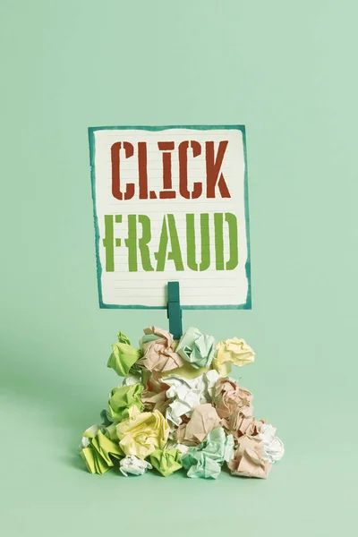 Word writing text Click Fraud. Business concept for practice of repeatedly clicking on advertisement hosted website Reminder pile colored crumpled paper clothespin reminder blue background.
